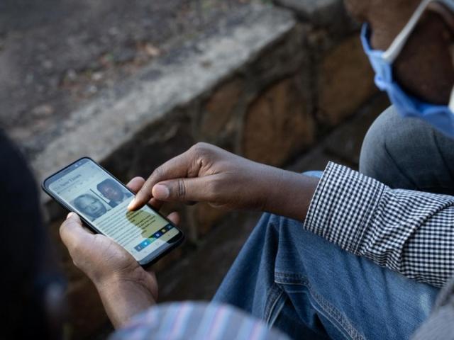 A man looks at his smartphone in Kigali, Rwanda, on May 18, 2020. A number of African governments have crafted laws on false information. Photo: AFP/SIMON WOHLFAHRT