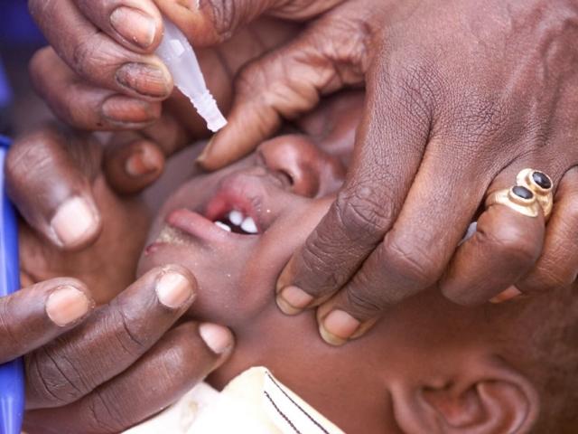 Un enfant se fait vacciner contre la poliomyélite dans un quartier de la banlieue de Dakar le 21 Novembre 2002 en marge de la réunion internationale, dite des "partenaires de l'alliance mondiale pour les vaccins et l'immunisation" (GAVI)  à Dakar. SEYLLOU DIALLO / AFP