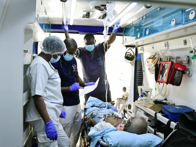 Un médecin urgentiste, un infirmier et un agent de santé soignent un patient dans une ambulance du Service médical d'urgence (SAMU) lors d'un transfert à Ouakam, dans la banlieue de Dakar, le 24 août 2021.