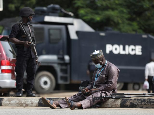 A journalist sits outside a court  in Nigeria.