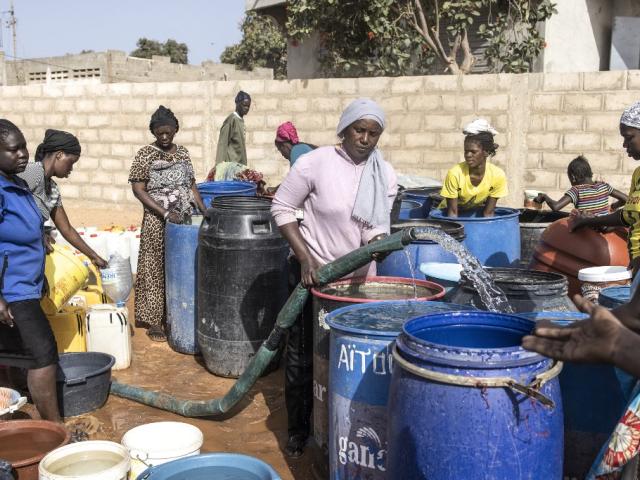 Des femmes vont chercher de l'eau potable dans un camion-citerne après avoir été privées d'eau pendant environ quatre semaines à Toubab Dialaw, au Sénégal, le 22 mars 2022