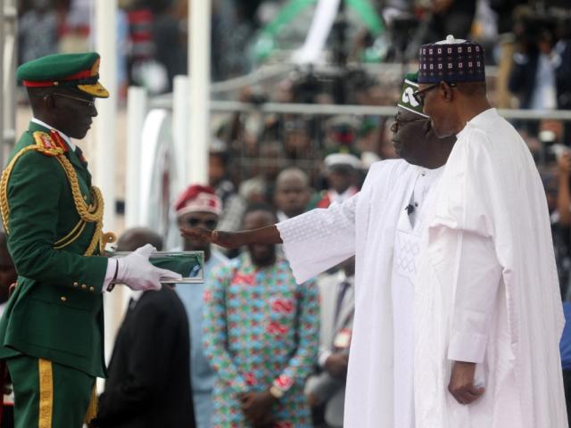 Nigeria's new president Bola Tinubu (middle) takes the oath of office during his inauguration in Abuja on 29 May 2023