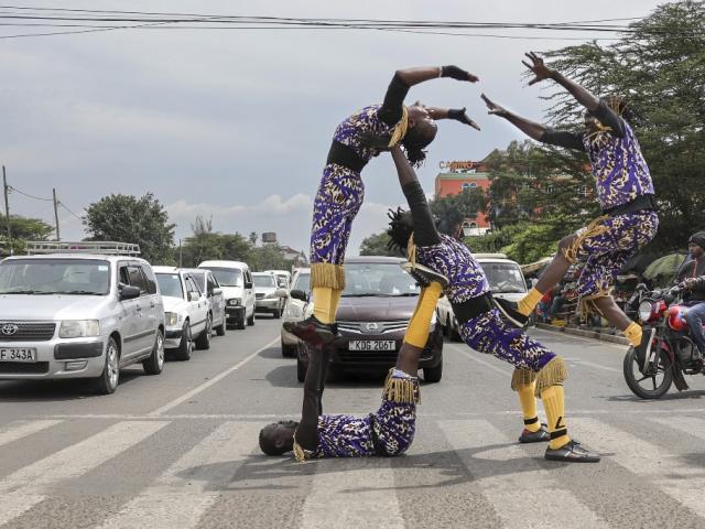 A self-taught acrobatic quartet performs stunts at a traffic light junction in the Kenyan capital Nairobi on 18 January 2024.