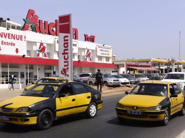 Des voitures passent devant un supermarché du groupe français Auchan, le 24 octobre 2017 dans le quartier de Yoff à Dakar, alors que le groupe français a renforcé sa présence dans la capitale sénégalaise après avoir racheté les magasins City Dia. SEYLLOU / AFP