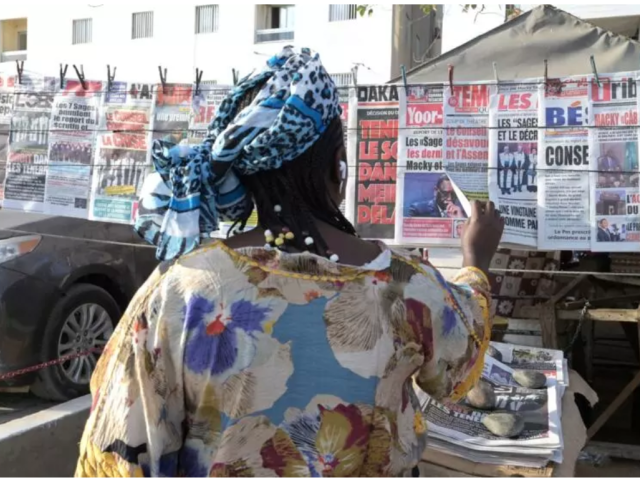 Une femme sénégalaise lisant les titres de la presse sénégalaise à Dakar, le 16 février 2024. © SEYLLOU / AFP