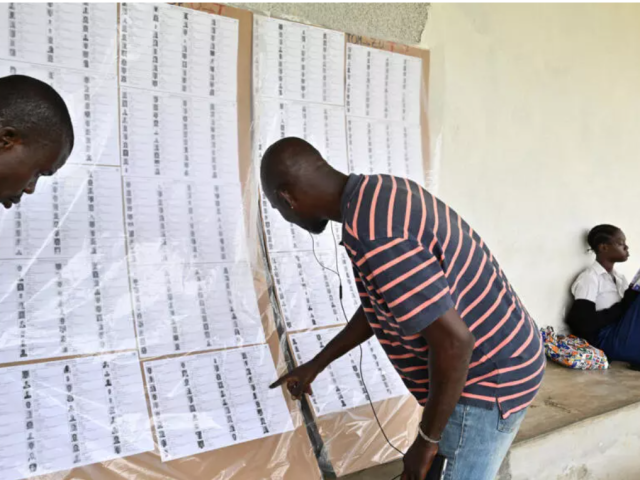 Des hommes cherchent leur nom sur les listes électorales, ici le 18 mars 2025 à Abidjan, pour l'élection présidentielle du 25 octobre 2025.