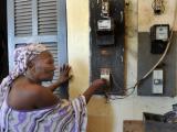 Une femme débranche son compteur électrique dans le but d'économiser de l'argent dans la cour d'un quartier de travailleurs à Dakar, le 10 juillet 2008. PHOTO AFP / GEORGES GOBET