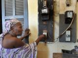 Une femme débranche son compteur électrique dans le but d'économiser de l'argent dans la cour d'un quartier ouvrier à Dakar, le 10 juillet 2008. Plusieurs centaines de personnes, répondant à l'appel des femmes de la principale coalition d'opposition, ont participé à un rassemblement le 9 juillet, pour protester contre la hausse du prix de l'essence et la rareté des produits alimentaires de base. PHOTO AFP / GEORGES GOBET