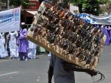 Un vendeur ambulant vend des lunettes dans les rues de Dakar lors d'un rassemblement organisé à l'occasion de la fête du Travail, le 1er mai 2009. Des rassemblements avaient eu lieu dans le monde entier, les organisateurs promettant, partout, de mettre en évidence la colère du public face à la récession paralysante qui a fait perdre leur emploi à des millions de personnes. GEORGES GOBET / AFP