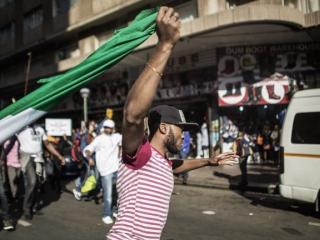 A man holds a Nigerian flag as thousands march through the streets of Johannesburg against the wave of xenophobic attacks that took place in South Africa in 2015. Photo: AFP/GIANLUIGI GUERCIA