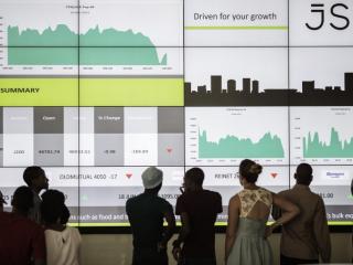 A school group looks at an electronic screen with stock index figures at the Johannesburg Stock Exchange (JSE) in March 2015. Photo: AFP/GIANLUIGI GUERCIA